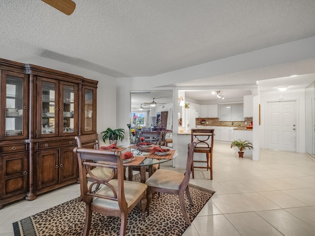 tiled dining room featuring ceiling fan and a textured ceiling