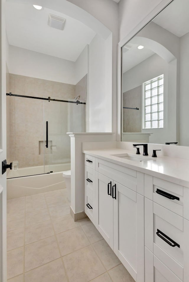 full bathroom featuring tile patterned flooring, vanity, toilet, and tiled shower / bath combo