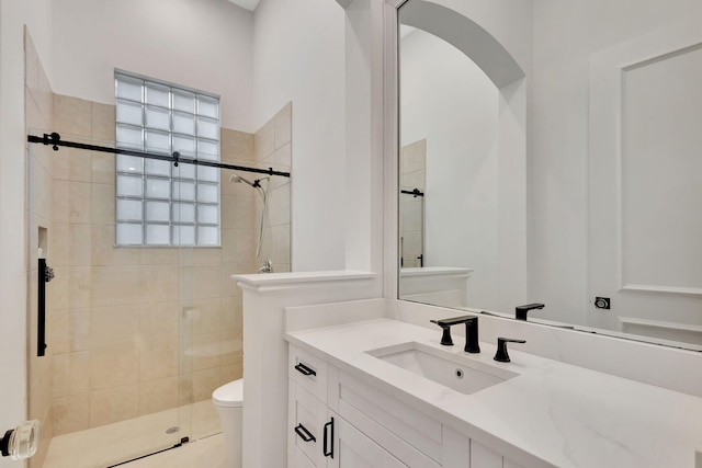 bathroom with toilet, tile patterned floors, vanity, and a shower with door