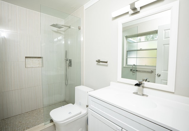 bathroom featuring vanity, toilet, and tiled shower