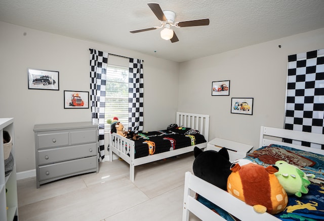 bedroom featuring ceiling fan, a textured ceiling, and light tile patterned flooring