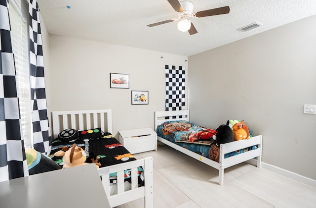 bedroom with a textured ceiling and ceiling fan