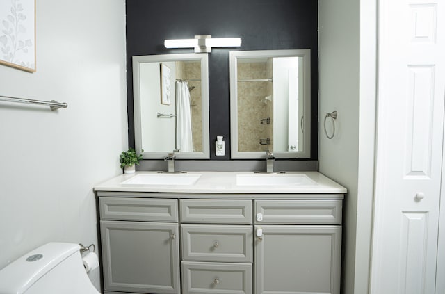 bathroom featuring toilet, vanity, and a shower with shower curtain