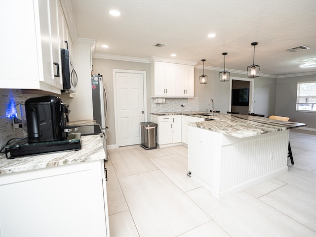 kitchen with decorative backsplash, a breakfast bar area, kitchen peninsula, pendant lighting, and white cabinets