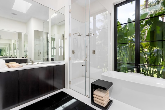 bathroom with vanity and shower with separate bathtub