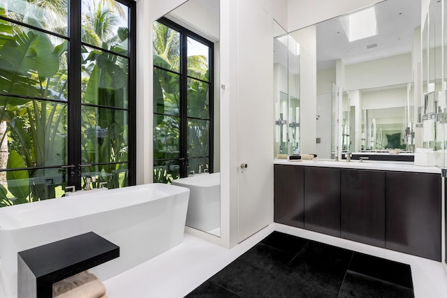 bathroom featuring vanity, french doors, a bath, and tile patterned flooring