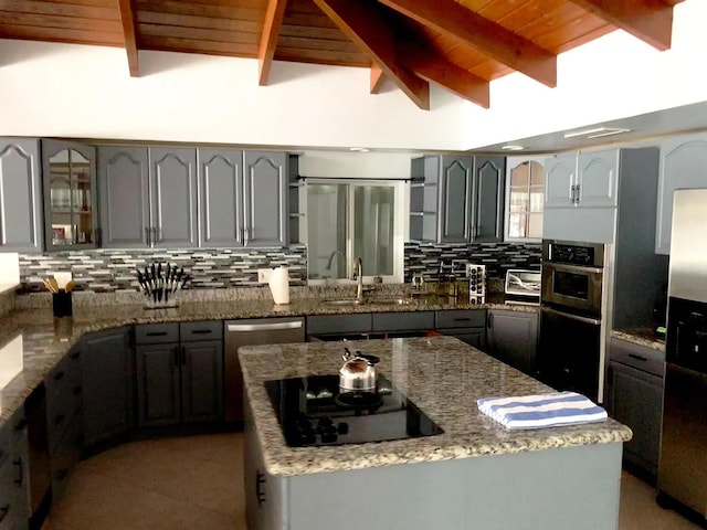1740 SE 7th St, Fort Lauderdale, FL 33316 - kitchen featuring light stone counters, appliances with stainless steel finishes, a sink, tasteful backsplash, and wood ceiling