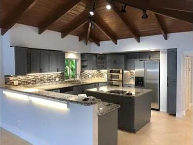 1740 SE 7th St, Fort Lauderdale, FL 33316 - kitchen with appliances with stainless steel finishes, a sink, a peninsula, wooden ceiling, and tasteful backsplash