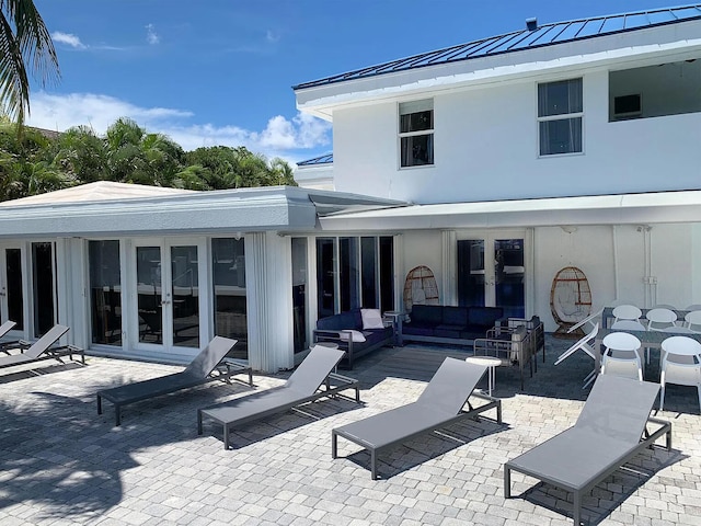 rear view of property featuring a patio area, french doors, and outdoor lounge area