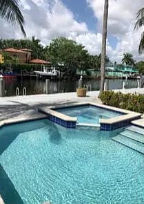 view of pool with a water view and a hot tub