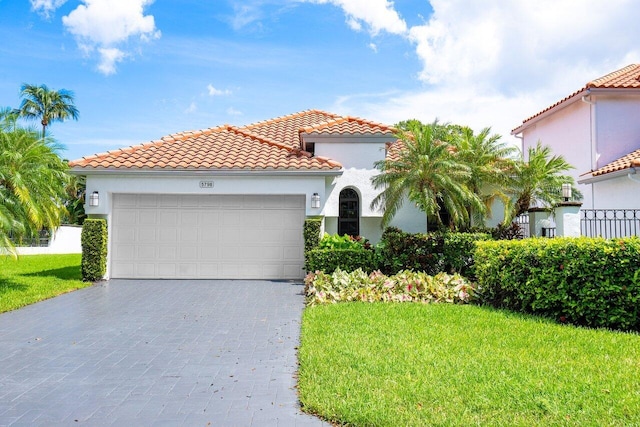 mediterranean / spanish-style home with a front yard and a garage