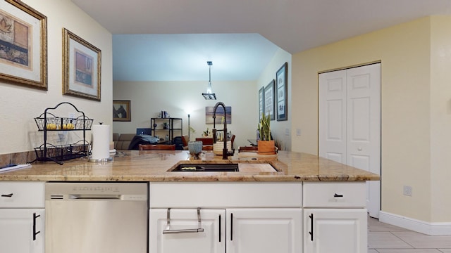 kitchen with light stone countertops, white cabinetry, sink, stainless steel dishwasher, and light tile patterned flooring