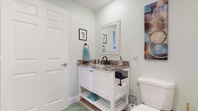 bathroom featuring hardwood / wood-style flooring, vanity, and toilet