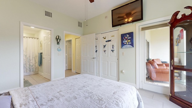 bedroom featuring ensuite bathroom, ceiling fan, light tile patterned flooring, and lofted ceiling