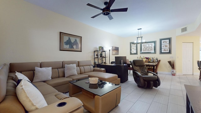 tiled living room with ceiling fan with notable chandelier