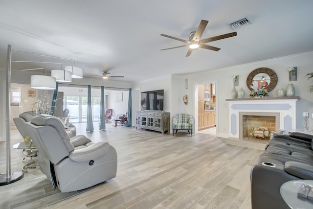 living room featuring light hardwood / wood-style floors, ceiling fan, and crown molding