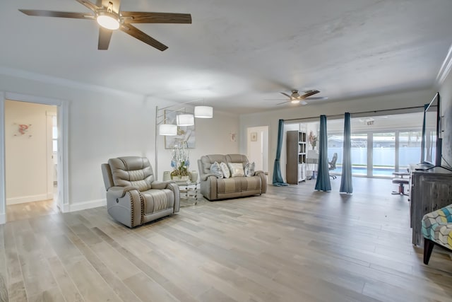 living room featuring ceiling fan and light hardwood / wood-style flooring