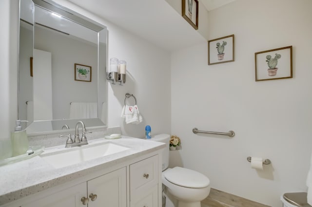 bathroom with vanity, toilet, and wood-type flooring