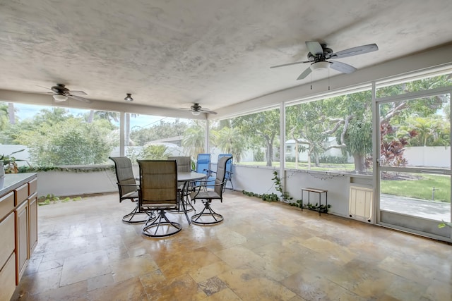 sunroom featuring ceiling fan and a healthy amount of sunlight