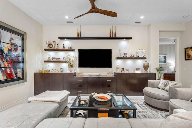 living room with ceiling fan and a textured ceiling