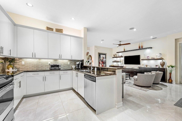 kitchen with white cabinetry, sink, kitchen peninsula, appliances with stainless steel finishes, and ceiling fan