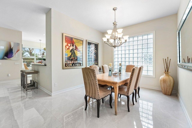 dining area with a textured ceiling and a notable chandelier