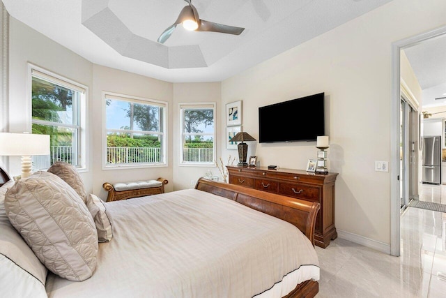 bedroom featuring ceiling fan, a textured ceiling, stainless steel fridge, and a tray ceiling