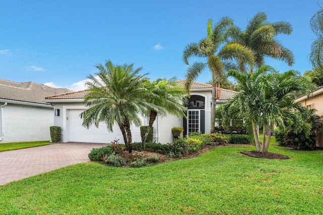 mediterranean / spanish house featuring a front lawn and a garage