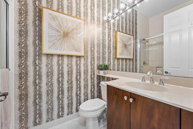 bathroom featuring vanity, tile patterned flooring, toilet, and a tile shower