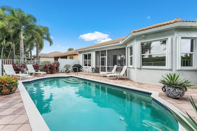 view of swimming pool with a patio and a sunroom