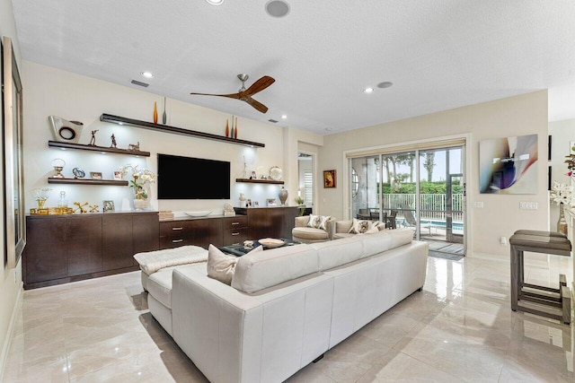 living room featuring a textured ceiling and ceiling fan