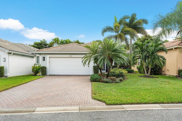 mediterranean / spanish-style home featuring a garage and a front lawn