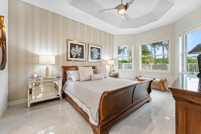 bedroom with ceiling fan and a tray ceiling