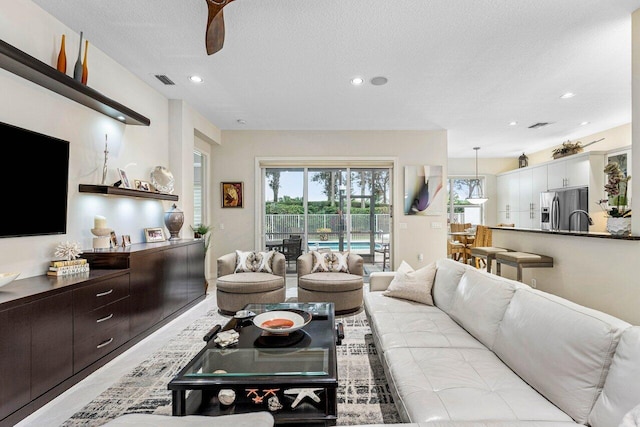 living room featuring a textured ceiling and ceiling fan