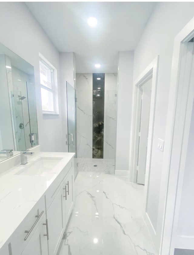 bathroom with vanity and a tile shower