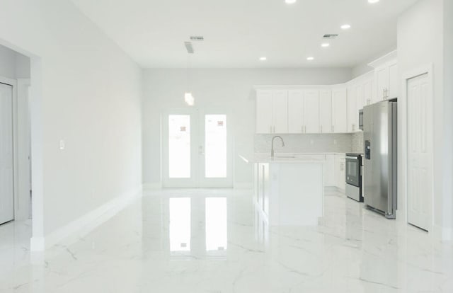 kitchen featuring white cabinetry, decorative backsplash, appliances with stainless steel finishes, a center island, and french doors