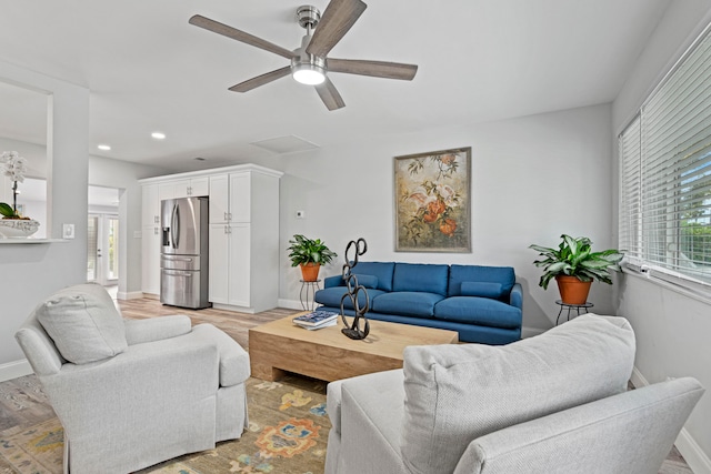 living room with light hardwood / wood-style floors, a wealth of natural light, and ceiling fan