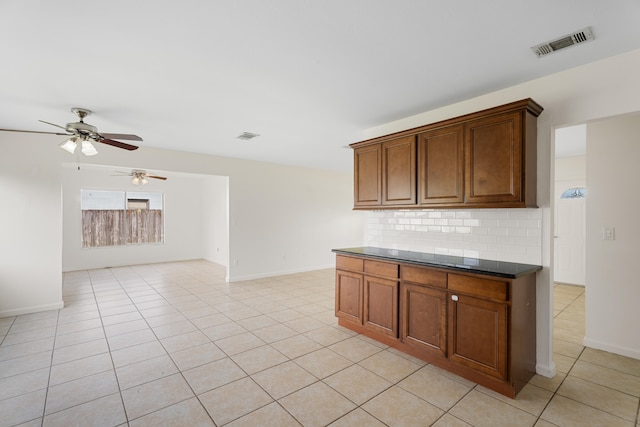 kitchen featuring ceiling fan, backsplash, and light tile patterned floors