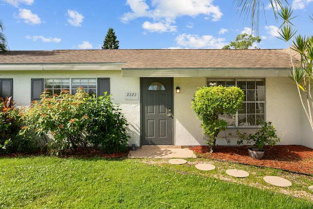 entrance to property featuring a lawn