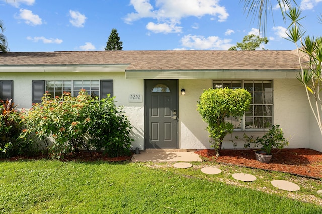 2222 SE Carnation Rd, Port Saint Lucie, FL 34952 - view of front of property featuring stucco siding, a front yard, and roof with shingles