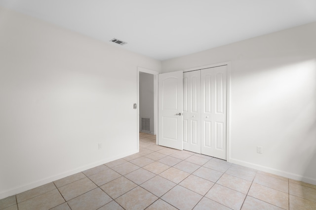 unfurnished bedroom with a closet and light tile patterned floors