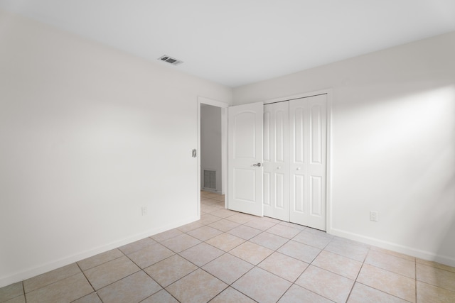 2222 SE Carnation Rd, Port Saint Lucie, FL 34952 - unfurnished bedroom with light tile patterned floors, baseboards, and a closet