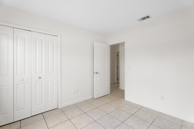 unfurnished bedroom featuring a closet and light tile patterned floors