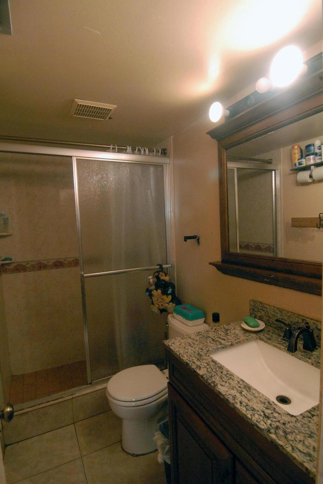 bathroom with vanity, toilet, tile patterned floors, and an enclosed shower