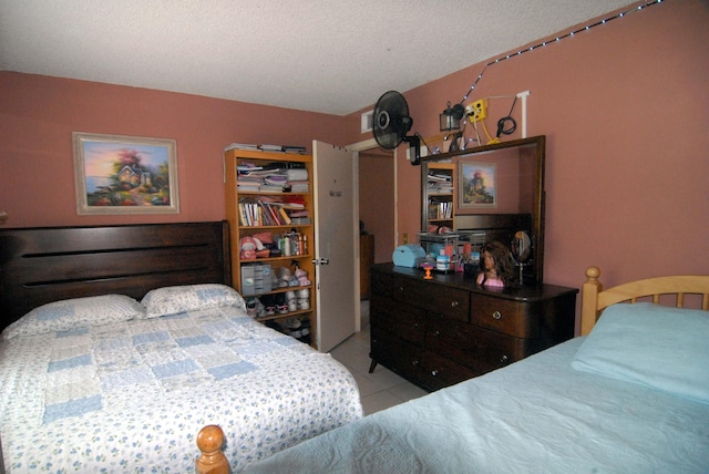 bedroom with a textured ceiling and light tile patterned flooring