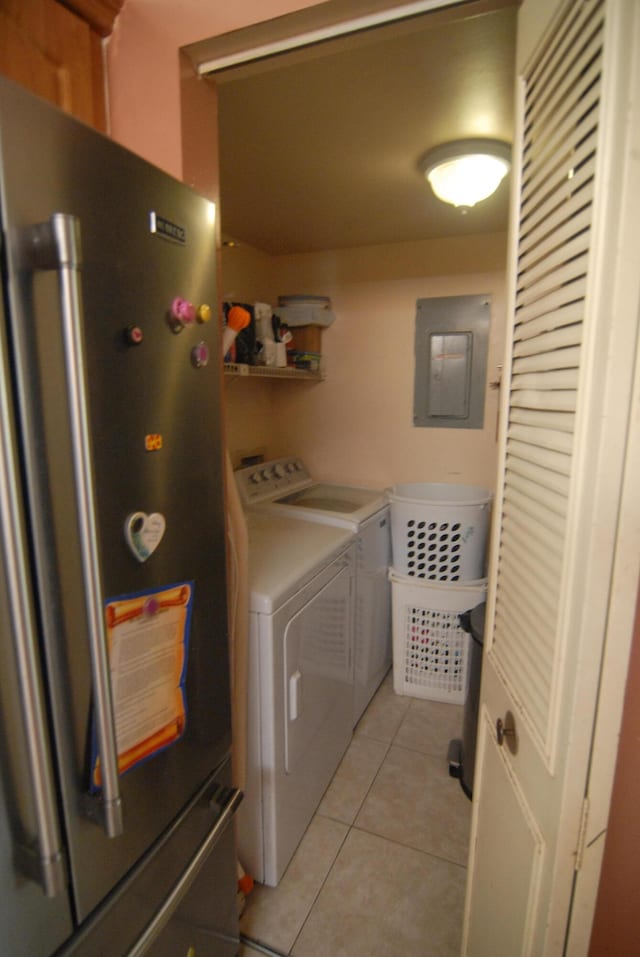 washroom featuring washer and dryer, electric panel, and light tile patterned floors