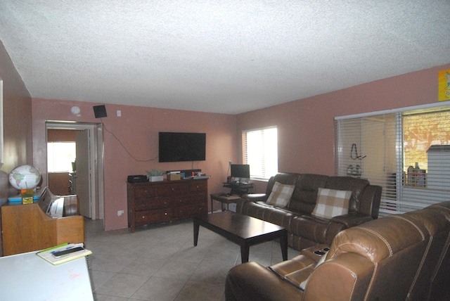 tiled living room featuring a textured ceiling