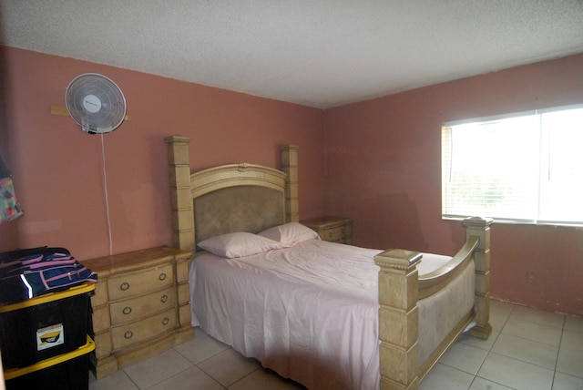 bedroom with a textured ceiling and light tile patterned floors