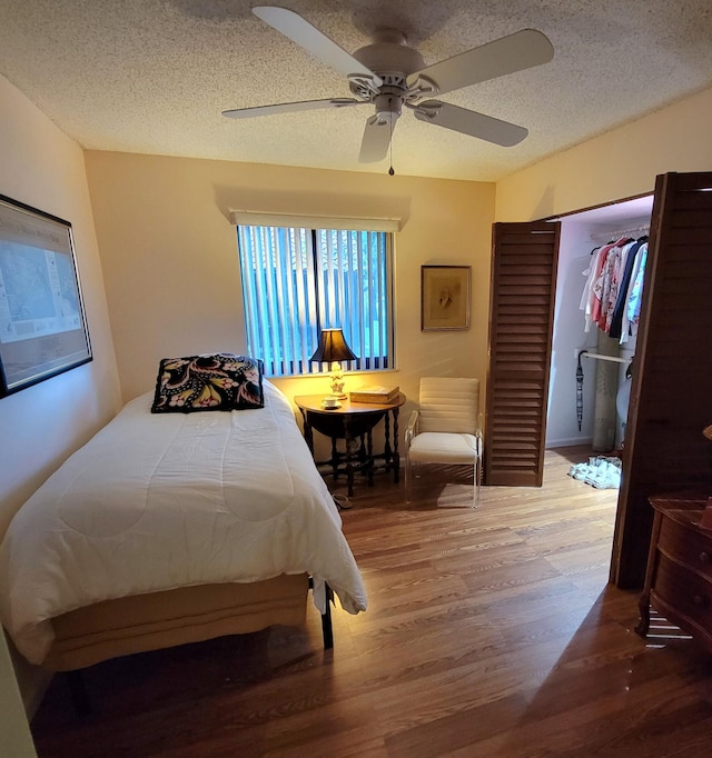 bedroom featuring a textured ceiling, wood-type flooring, and ceiling fan