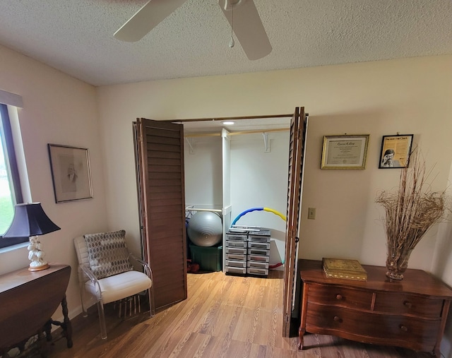 sitting room featuring a textured ceiling, hardwood / wood-style flooring, and ceiling fan